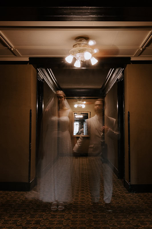 A couple poses for a haunting ghost photo inside of Crescent Hotel during their elopement in Eureka Springs, Arkansas.