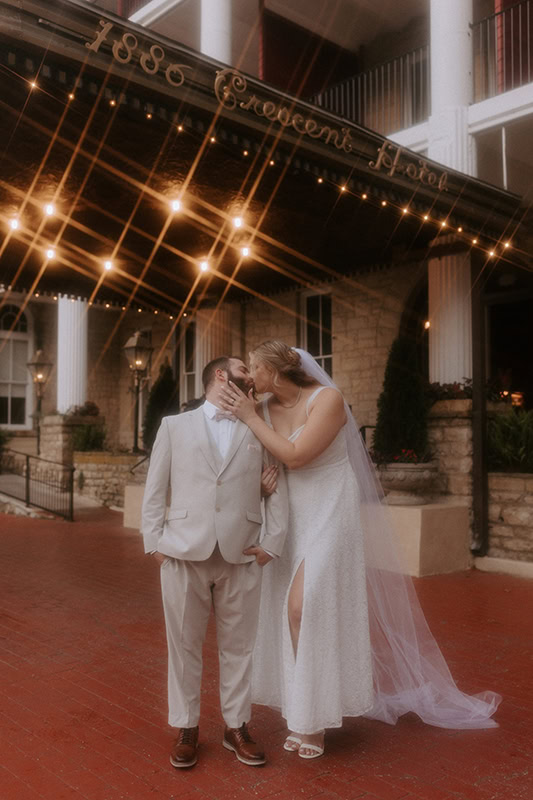 A couple embraces for a kiss outside of the Crescent Hotel in Eureka Springs, Arkansas for their elopement.