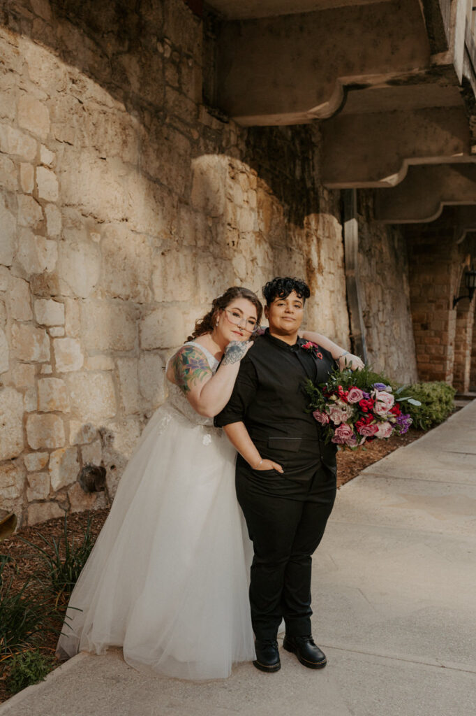 A couple in wedding attire embrace each other along the San Antonio Riverwalk during their elopement.