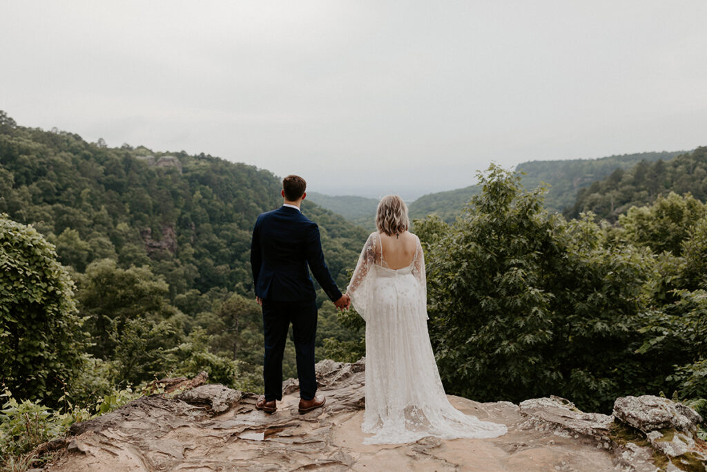 A bride and groom look out at the views of Petit Jean State Park outside of Mather Lodge during their Arkansas elopement.