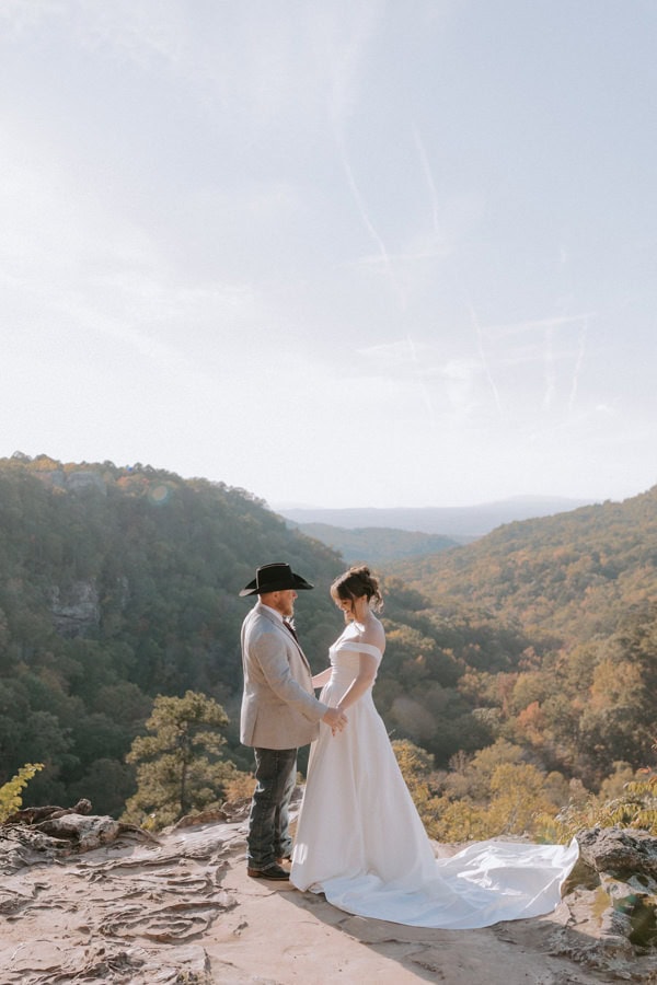A couple stands embracing in front of Mather Lodge Overlook during their Petit Jean State Park elopement in Arkansas.