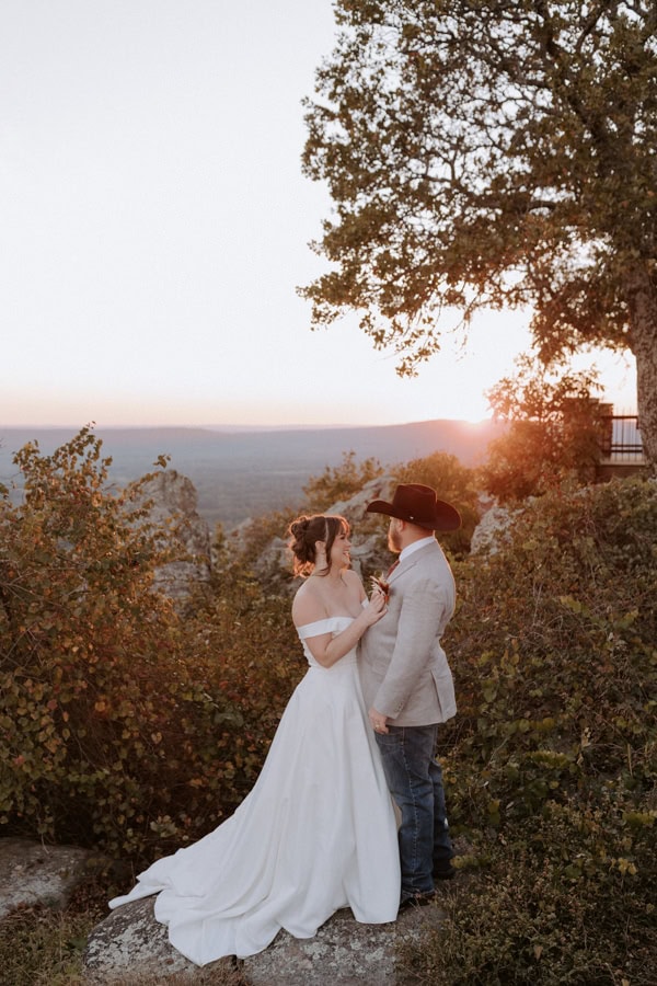 a bride and groom embrace while they watch the sunset at Petit Jean State Park during their Arkansas Elopement.