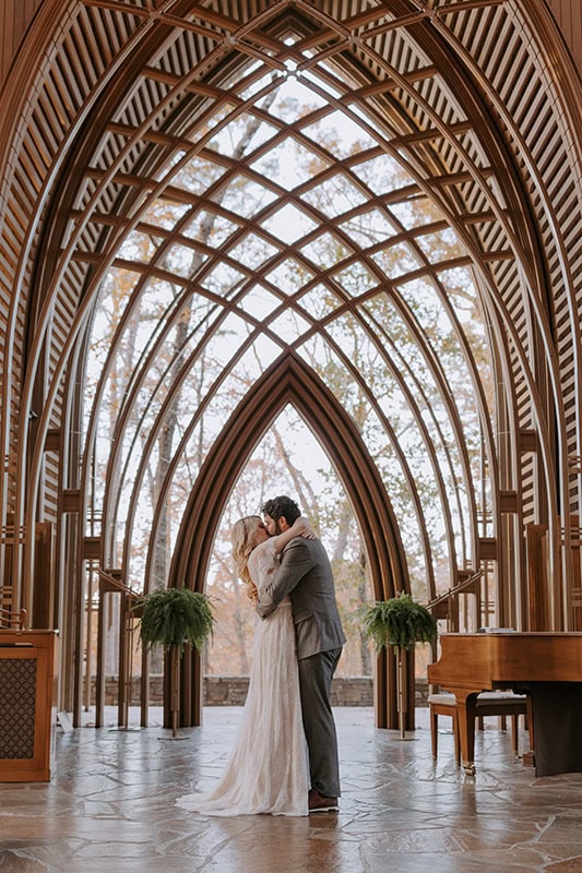 A couple kisses at the altar during their Arkansas elopement at Mildred B. Cooper Memorial Chapel in Bella Vista, Arkansas.