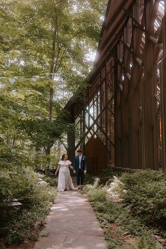 A couple walks through a hidden passageway on the side of Anthony Chapel after their Arkansas elopement.