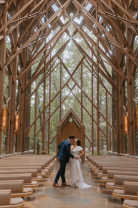 A couple kisses in the middle of the aisle of Anthony Chapel during their elopement.