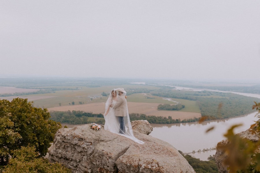 A bride and groom embrace under the bride's veil during their elopement photos at Petit Jean State Park in Arkansas.