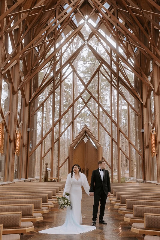 A couple poses for a photo inside of Anthony Chapel at Garvan Woodland Gardens for their elopement photos.