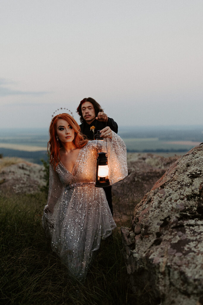 A bride and groom walk down a path at Petit Jean State Park during blue hour while exploring for their Arkansas elopement.