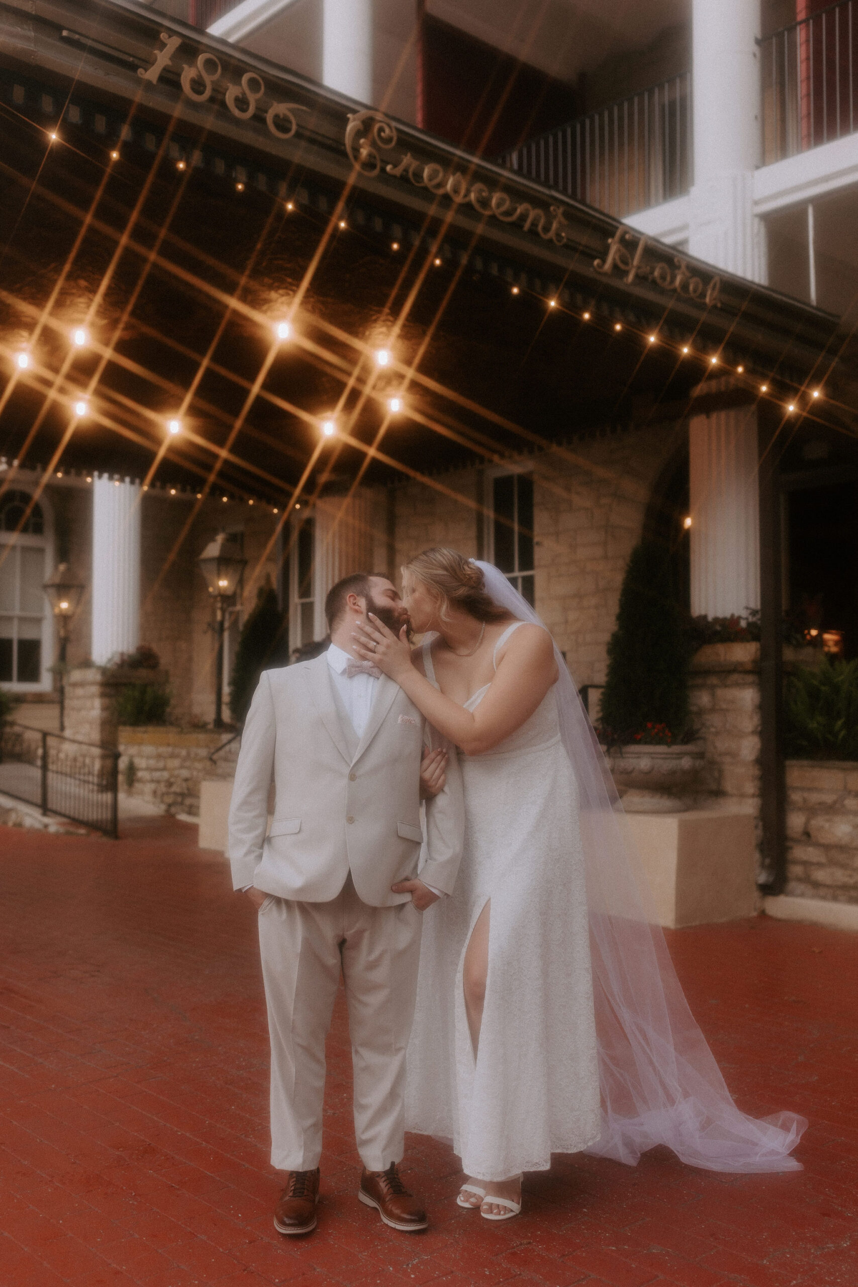 An Arkansas elopement couple stand in front of Crescent Hotel in Eureka Springs kissing.