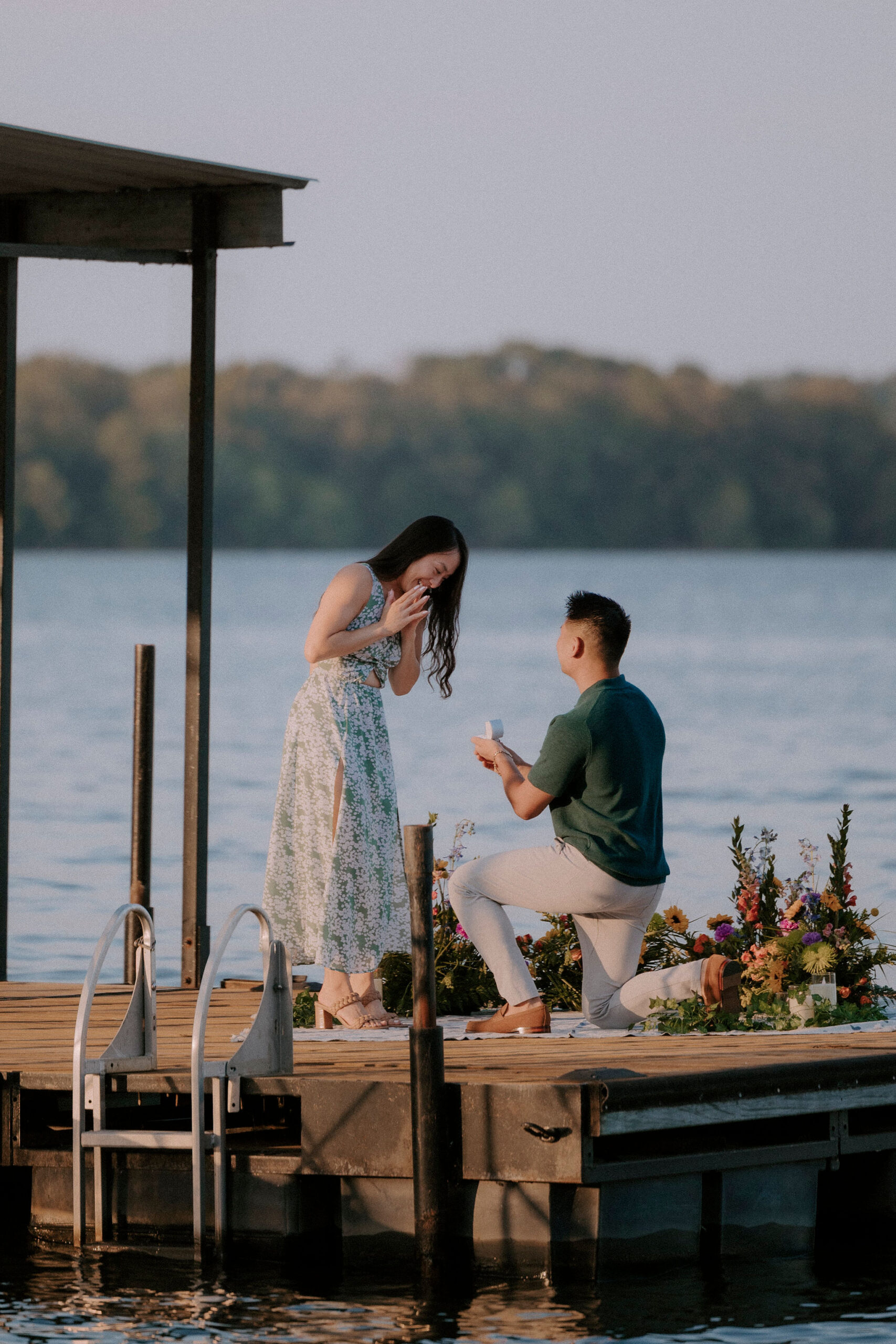 A man is on one knee proposing to his girlfriend on Lake Hamilton in Hot Springs, Arkansas.