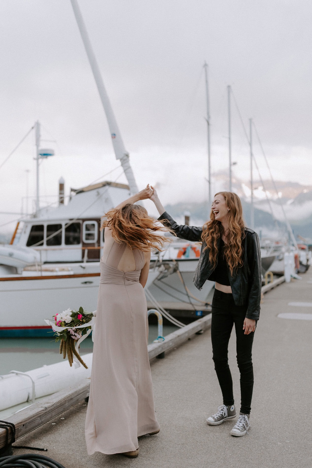 A couple dances down an aisle of the Seward Boat Harbor during their Alaska elopement.