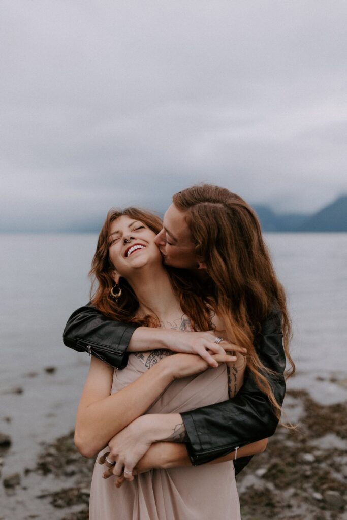 A bride kissing her spouse on the beach in Seward, Alaska.