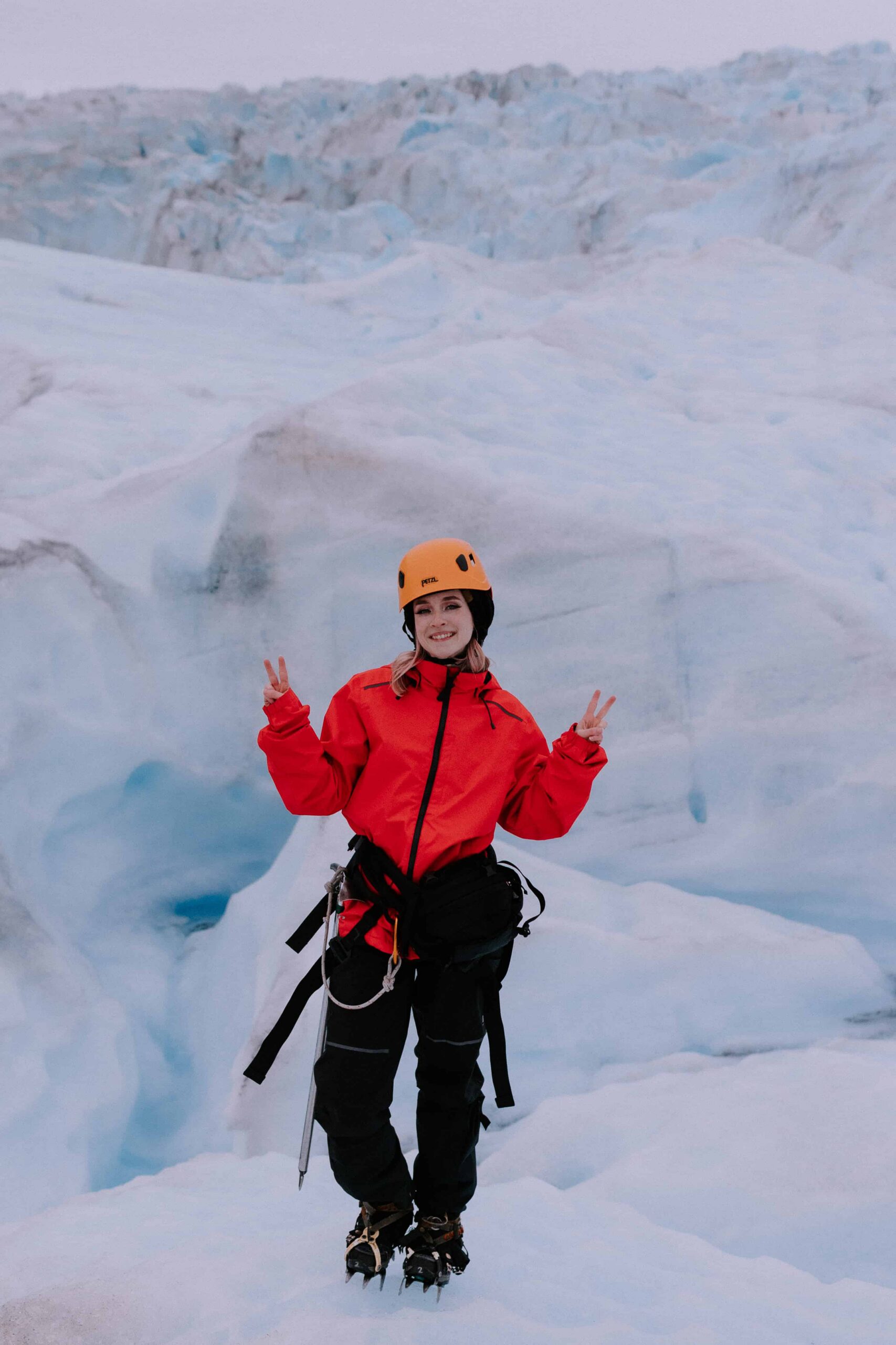 An Alaska elopement photographer posing for a photo on Mendenhall Glacier in Juneau, Alaska.