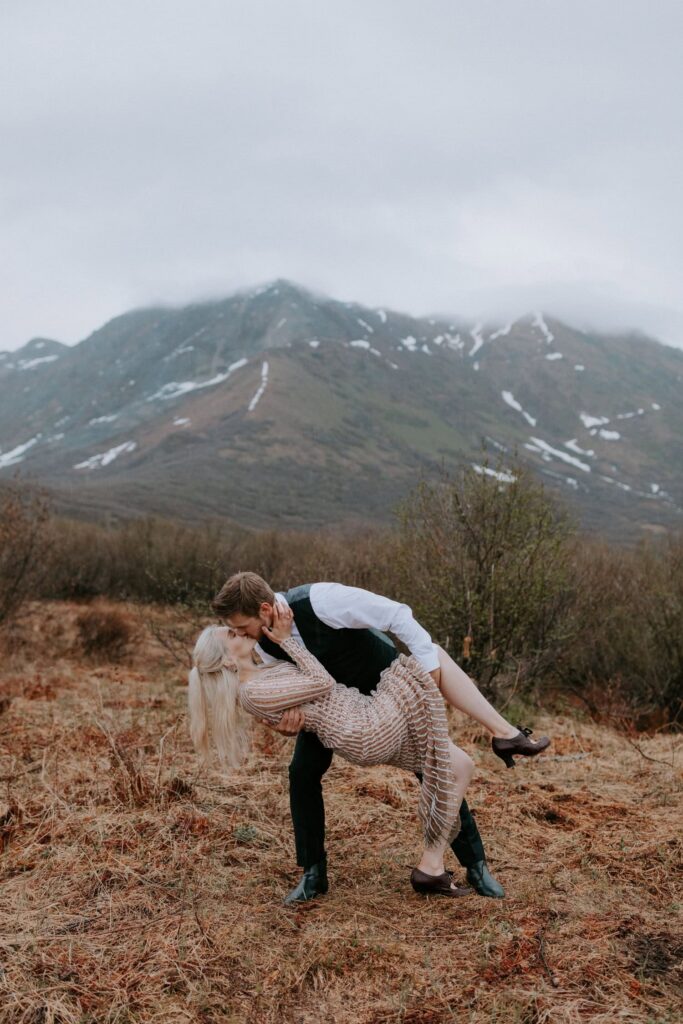 A groom dips his bride down for a kiss on the Gold Mint Trail during their Alaska Hatcher Pass elopement.
