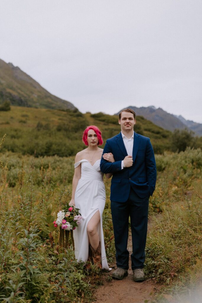 A couple poses for a photo on the Gold Mint Trail in Hatcher Pass Alaska during their elopement.