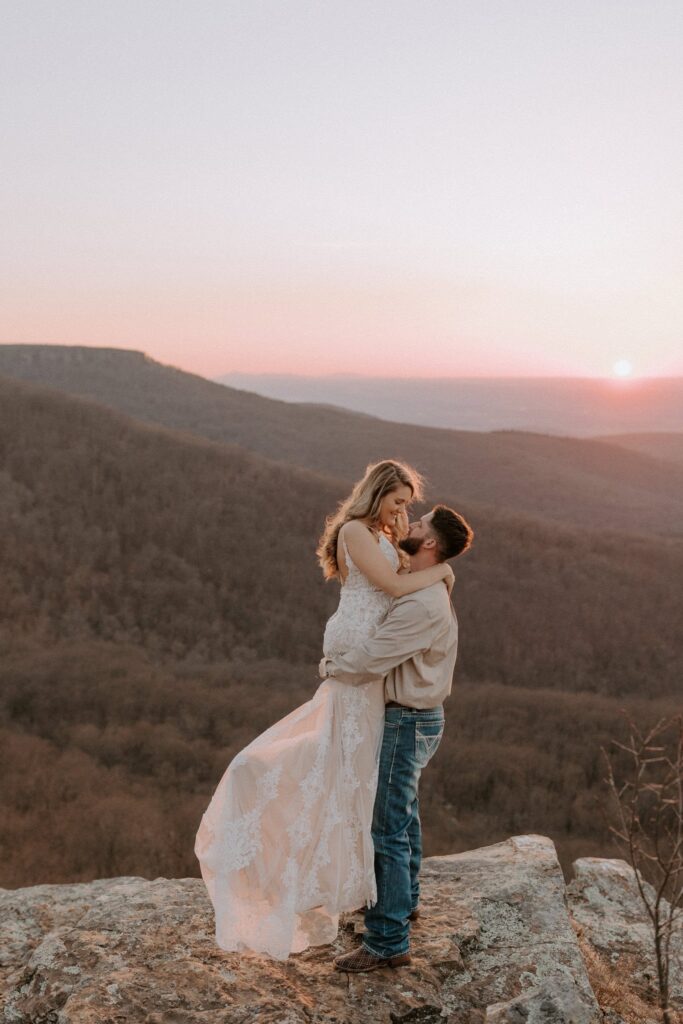 A couple poses for a photo during a pink sunset at Mount Magazine State Park during their Arkansas elopement.