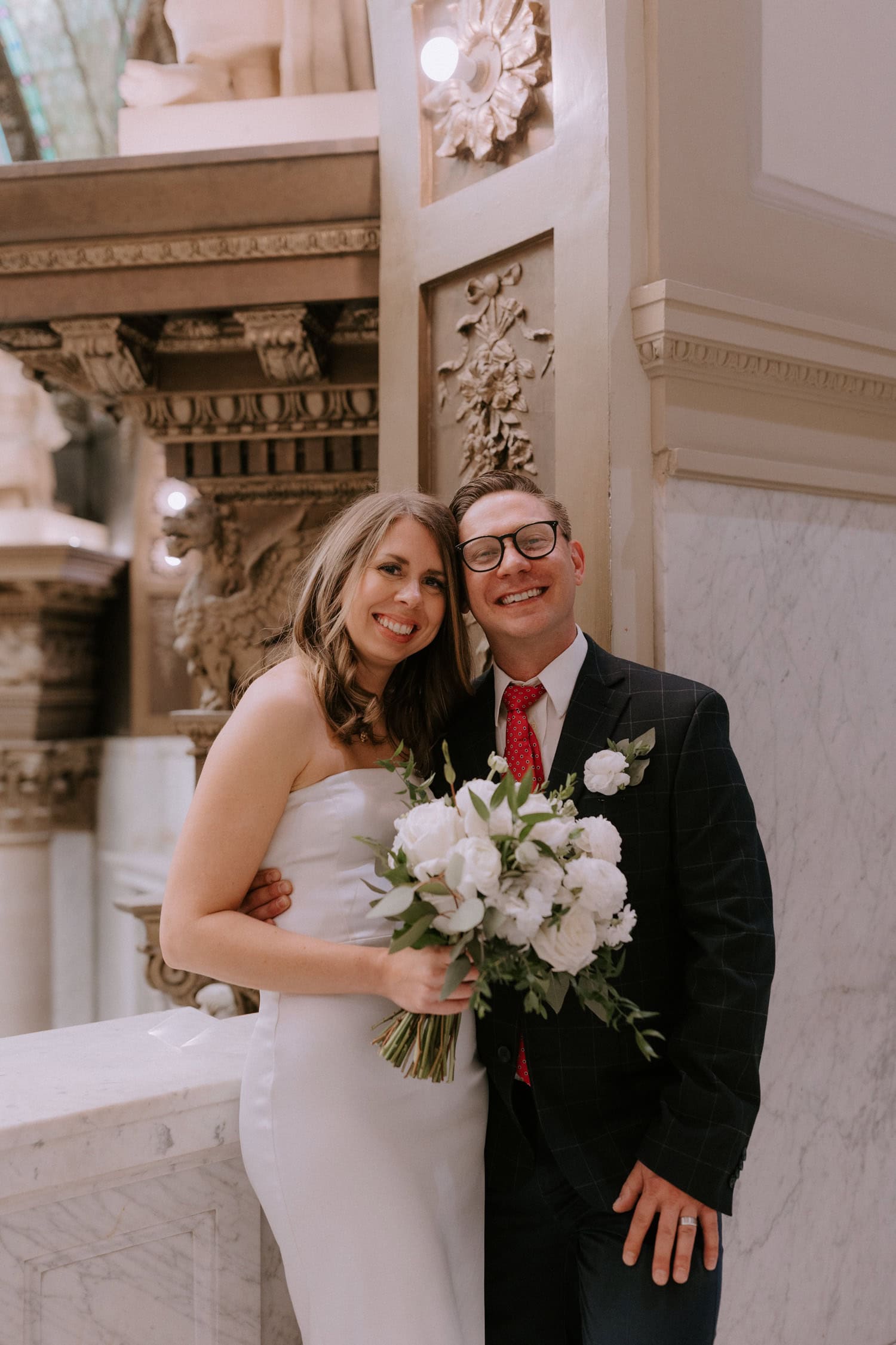 A bride and groom pose and smile for a photo after their elopement ceremony at Pulaski County Courthouse in Little Rock, Arkansas.