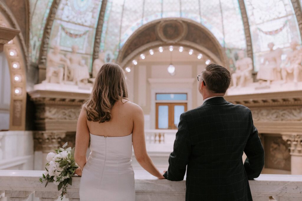 A couple looks out at the stained glass dome at the Pulaski County Courthouse in Little Rock, Arkansas after their elopement.
