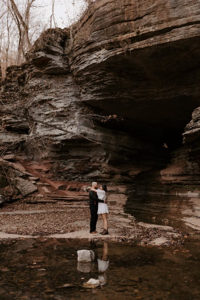 A couple embraces after their elopement ceremony outside of the Natural Bridge at Lost Valley Trail in Ponca, Arkansas.