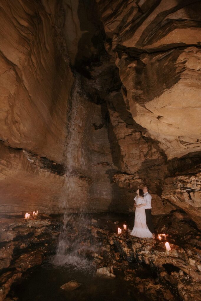 A bride and groom look up at Eden Falls at Lost Valley Trail while caving for their vow renewal in Ponca, Arkansas.