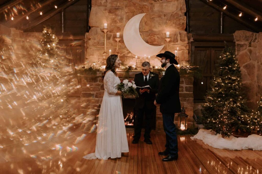 A bride and groom laugh with each other during their candlelit wedding inside the Mt. Nebo pavilion. 