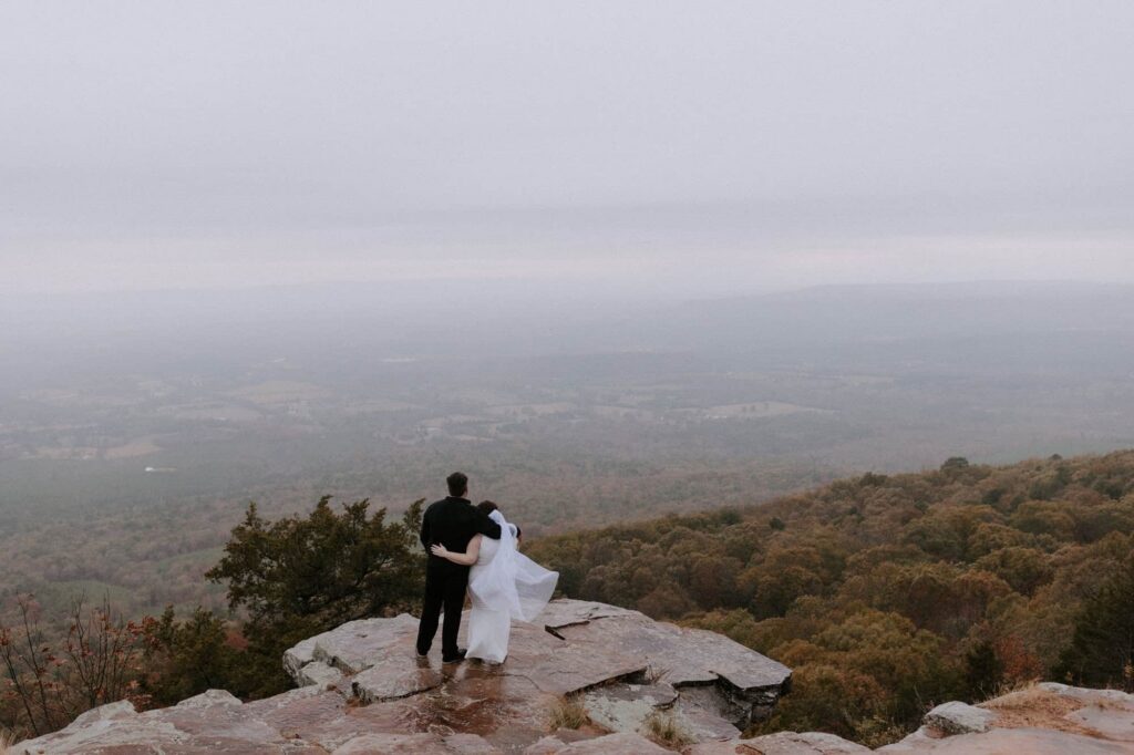 A bride and groom look out over the valley from the Sunrise Pt. Overlook during their Mt. Nebo elopement in Arkansas.