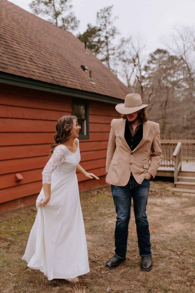 A bride laughs while showing her little brother her wedding dress for the first time outside of the Mt. Nebo State Park cabins.