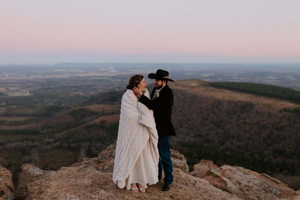 A couple stands on Mt. Nebo during their chilly winter elopement in Arkansas.
