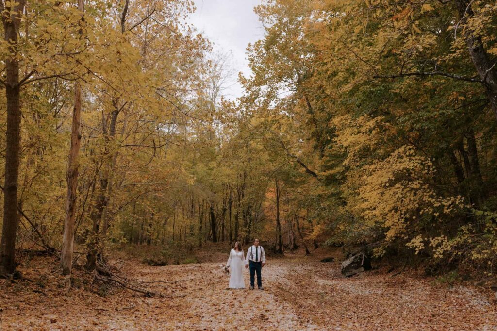 A couple stands in a dry river bed of the Buffalo National river during their autumn elopement in Arkansas.